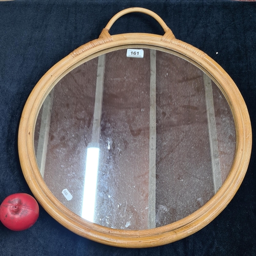 161 - A circular mirror housed in a well made bamboo frame featuring woven bamboo on the back