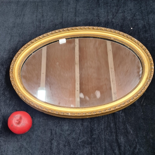 162 - A beautiful wall hung, oval mirror housed in a gilt gold frame.