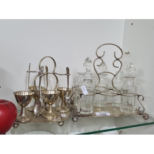 184 - An early 2oth century plated egg set, along with an early 20th century glass cruet set including fiv... 