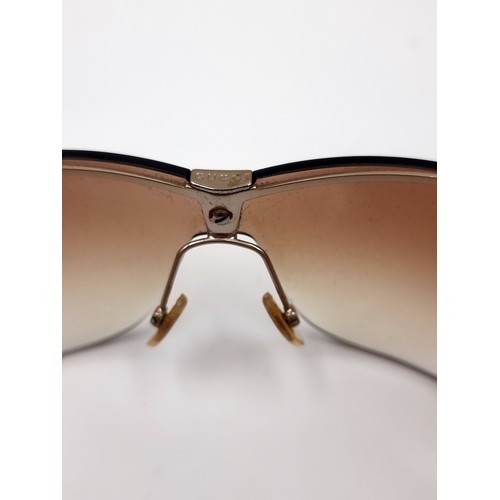 35 - A pair of genuine designer Gucci wrap around style sunglasses marked Gucci to frames. Lenses in clea... 