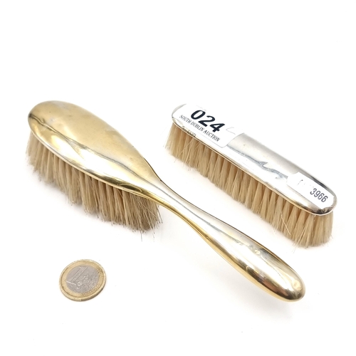 24 - Two silver items - A sterling silver hair brush together with a clothes brush. Hallmarked London. Ma... 