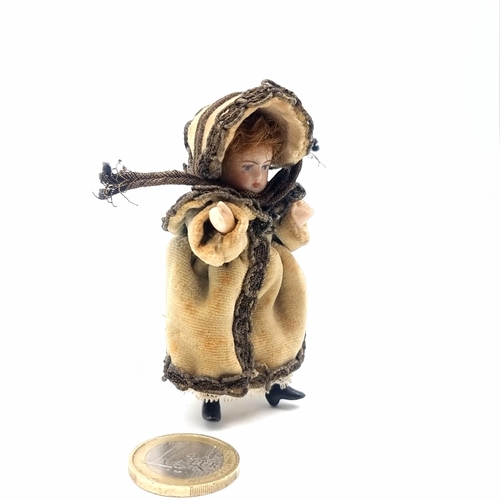 31 - An antique bisque miniature doll with natural hair with attractive clothing. Height - 8 cms.