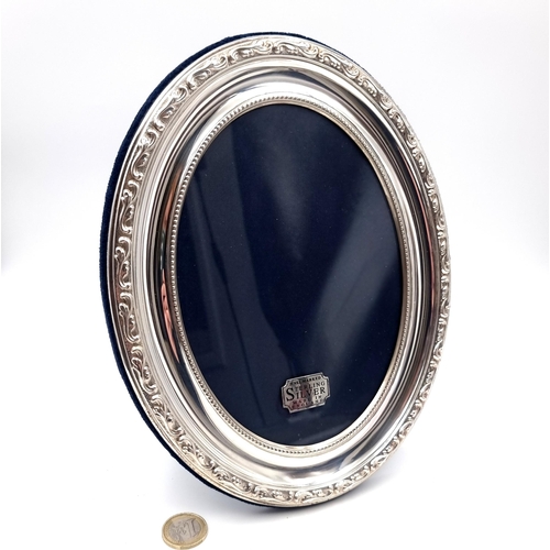 42 - A sterling silver Carrs of Sheffield oval photo frame. Set with a foliette design to rim. Dimensions... 