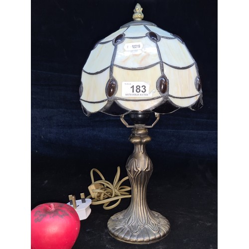 183 - An elegant bronze toned lamp featuring the iconic Tiffany style glass shade.