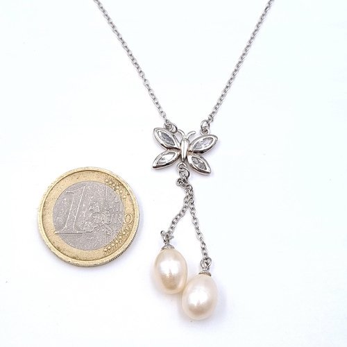 928 - A butterfly gem set natura pearl drop pendant and chain set in sterling silver. Length - 40 cms. Com... 