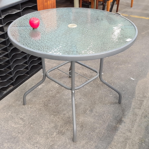 1004 - A round garden table with textured top.