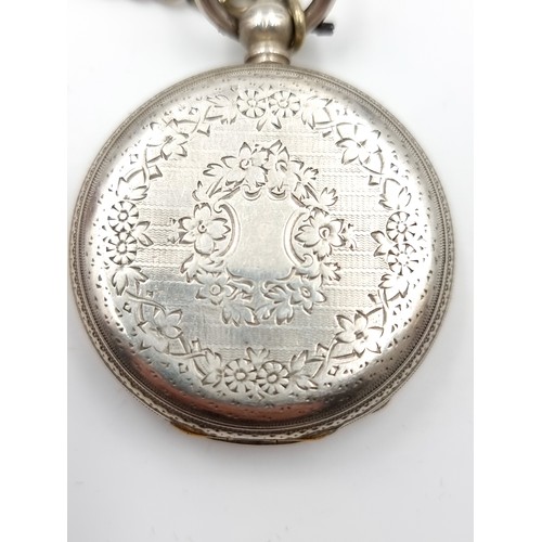 12 - A sterling silver pocket watch with white enamel face and roman numeral dial with a decorated cartou... 