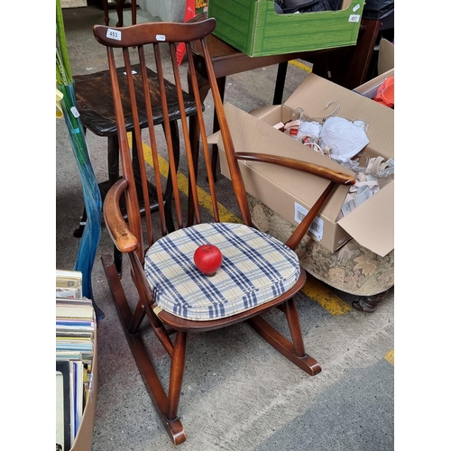 453 - A refined Ercol mid century rocking chair with spindle back and featuring nice curve detail to top r... 