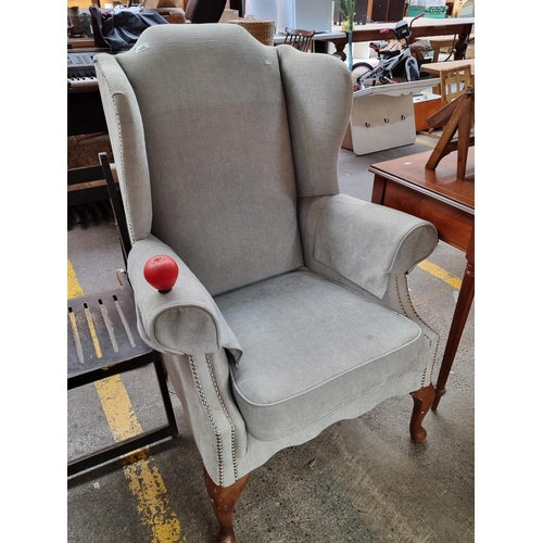 492 - A lovely wing back arm chair featuring chrome stud work and wooden cabriole legs. Super comfortable.... 