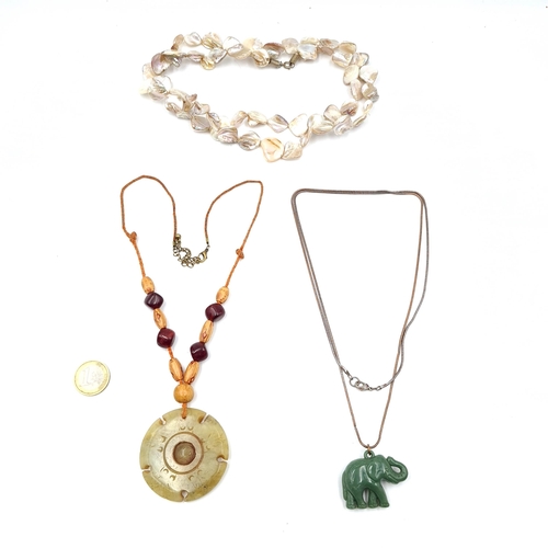 31 - An assorted collection of necklaces consisting of a mother of pearl example, a jade pendant and a ja... 