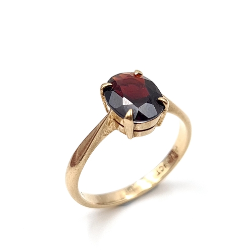 6 - A Large dark red gemstone ring set in raised claw mount set in nine carat gold. Ring size - L. Weigh... 