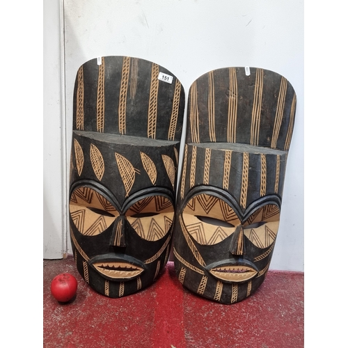 151 - A pair of striking large hand carved African tribal masks. Would look great wall mounted.