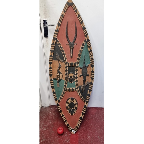 152 - Star Lot : An amazing painted ovoid African tribal sheild. With animals and masks in relief.