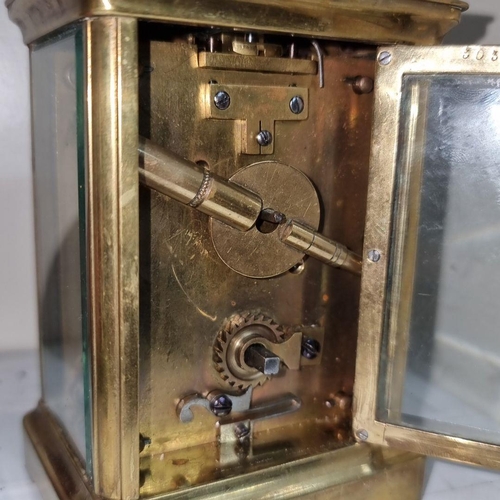 722 - A French antique brass carriage clock with Roman numeral dial and visible inner movement.