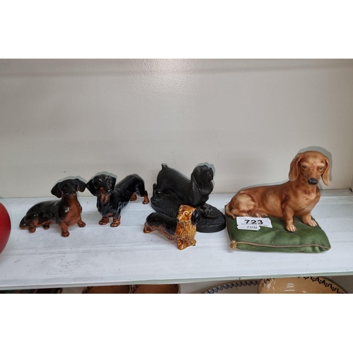 723 - A collection of six dachshund figurines in various poses, including one Heredities piece by Jean Spo... 