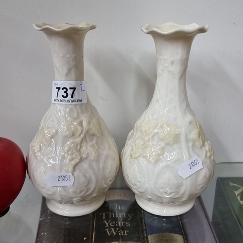 737 - A pair of Belleek Irish porcelain vases with floral embossed design, featuring flared rims.