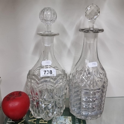 738 - A pair of intricately cut glass decanters with stoppers. Both feature geometric patterns and clear, ... 