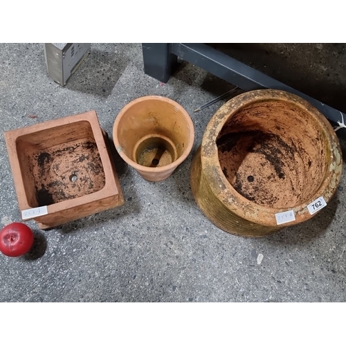 762 - Collection of three rustic terracotta planters, featuring one square and two rounded pots, ideal for... 