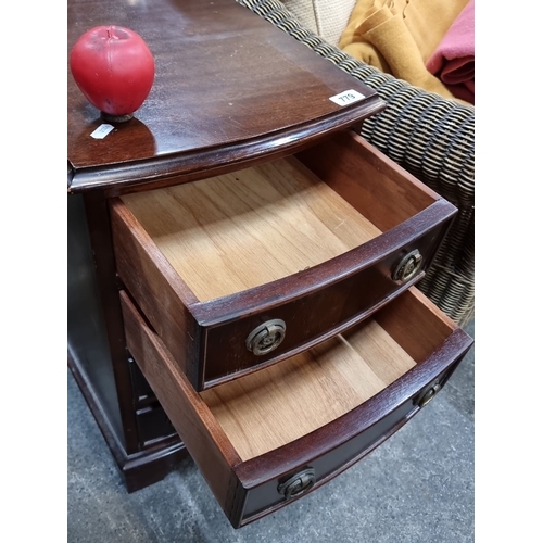 779 - Mahogany bedside chest with classic brass hardware, featuring four graduated drawers and elegant bal... 