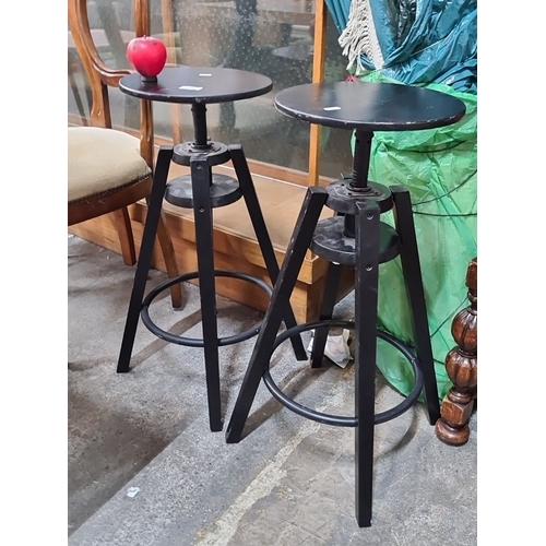 806 - Pair of industrial-style adjustable sculpture  stands , featuring black metal frames and round woode... 