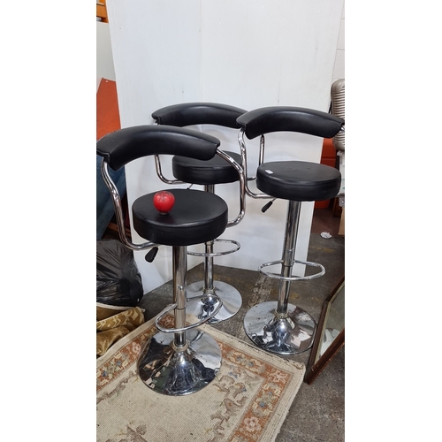 807 - Set of three contemporary adjustable bar stools with chrome finish and black faux leather seats, fea... 