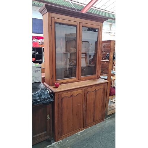 814 - Star Lot : Elegant Antique pine glazed bookcase featuring a glass-paneled upper cabinet and solid lo... 