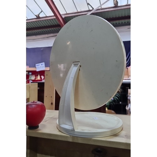 828 - Elegant, free-standing mid century vanity mirror with a minimalist white frame and round reflective ... 