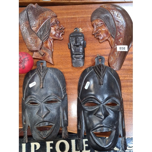 858 - Lot includes a collection of six African tribal masks, showcasing intricate carvings and traditional... 