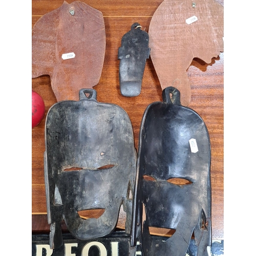 858 - Lot includes a collection of six African tribal masks, showcasing intricate carvings and traditional... 