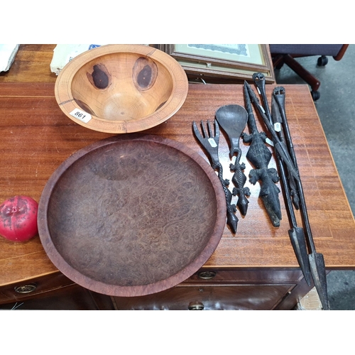 861 - Lot includes intricately carved wooden tribal utensils and two decorative bowls, showcasing detailed... 