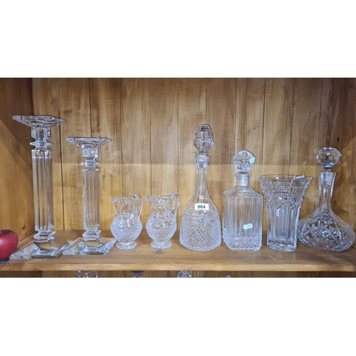 864 - Collection of elegant crystal glassware, featuring two candlesticks, three pitchers, three decanters... 