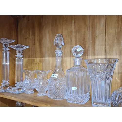 864 - Collection of elegant crystal glassware, featuring two candlesticks, three pitchers, three decanters... 