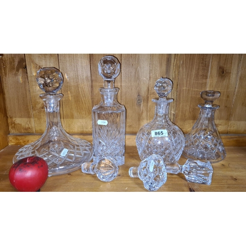 865 - Set of four intricately cut crystal decanters with faceted stoppers, showcasing classic European des... 