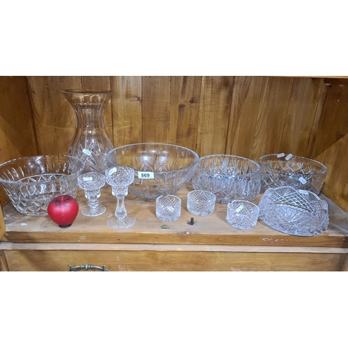 869 - Elegant collection of cut crystal glassware, comprising several bowls, two candle holders, and a vas... 