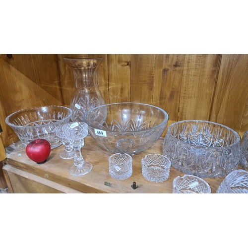 869 - Elegant collection of cut crystal glassware, comprising several bowls, two candle holders, and a vas... 