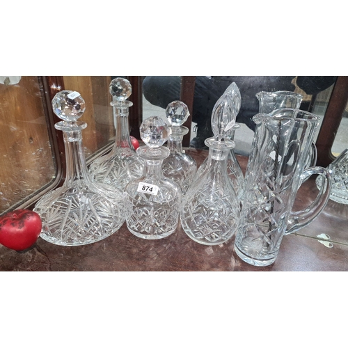 874 - Set of six intricately cut crystal decanters and pitchers, featuring classical faceted stoppers and ... 