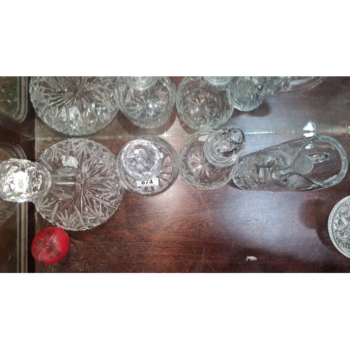 874 - Set of six intricately cut crystal decanters and pitchers, featuring classical faceted stoppers and ... 