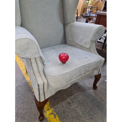 492 - A lovely wing back arm chair featuring chrome stud work and wooden cabriole legs. Super comfortable.... 