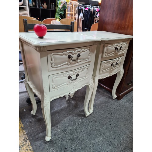 495 - A pair of French style bed side tables / cabinets, in white painted finish with carved detailing.