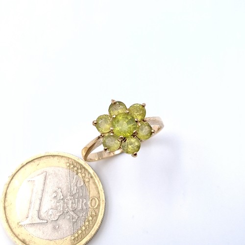 18 - An attractive daisy cluster Peridot ring set in nine carat gold. Ring size - N. Weight - 2.15 grams.... 