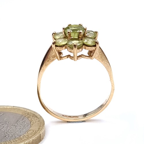 18 - An attractive daisy cluster Peridot ring set in nine carat gold. Ring size - N. Weight - 2.15 grams.... 