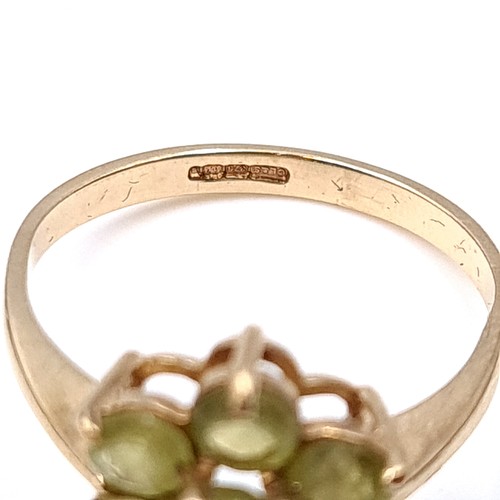 18 - An attractive daisy cluster Peridot ring set in nine carat gold. Ring size - N. Weight - 2.15 grams.... 