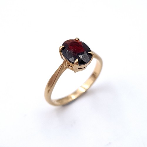 6 - A Large dark red gemstone ring set in raised claw mount set in nine carat gold. Ring size - L. Weigh... 