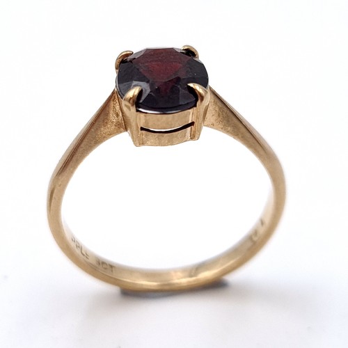 6 - A Large dark red gemstone ring set in raised claw mount set in nine carat gold. Ring size - L. Weigh... 