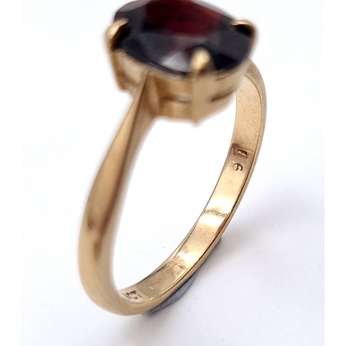 6 - A Large dark red gemstone ring set in raised claw mount set in nine carat gold. Ring size - L. Weigh... 