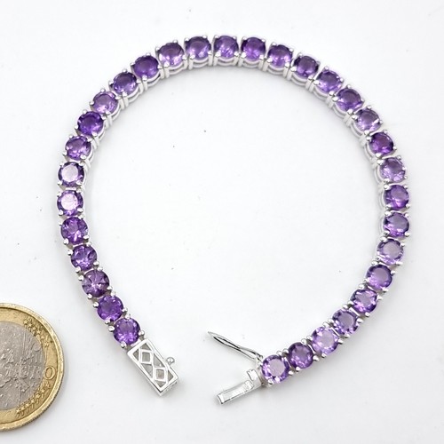 966 - Star lot : A very attractive 32 gemstone amethyst line bracelet set in sterling silver. Beautiful pi... 