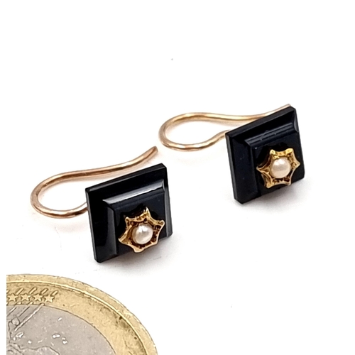 21 - A pair of nine carat gold onyx earrings set with seed pearl mounts. Suitable for pierced ears. Total... 