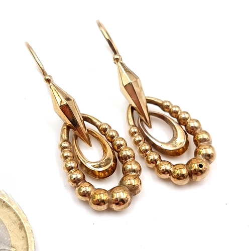 25 - A pair of nine carat gold hoop drop earrings. Suitable for pierced ears. Drop - 2.5 cms. Total weigh... 