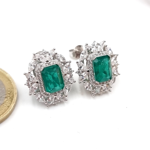 51 - A stunning pair of Lab Created Emerald facet cut stud earrings with gemstone surround. Weight - 5.43... 