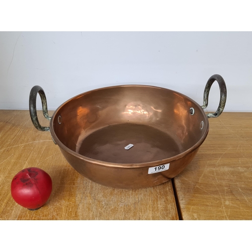 190 - A large antique copper preserve pan with heavy iron handles featuring a rolled edge. Heavy super qua... 